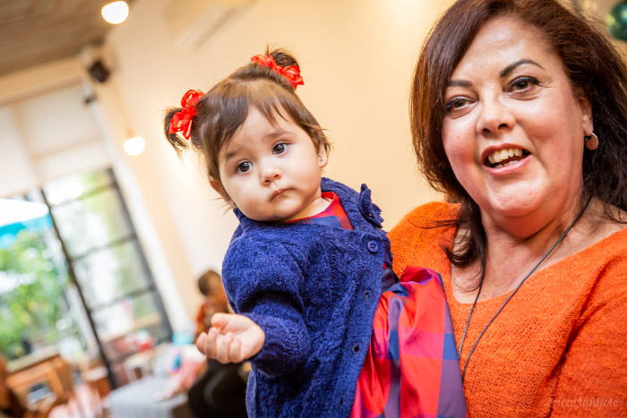 foto de festa vovó segurando a bebê aniversariante no colo.