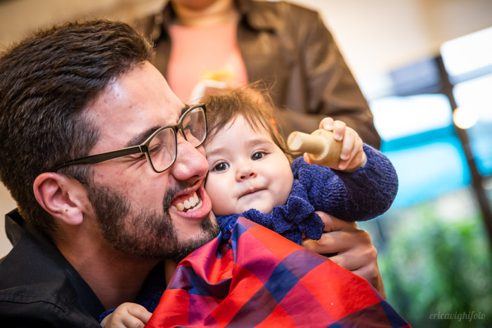 Tio dando uma abraço amassando a nenê aniversariante. 