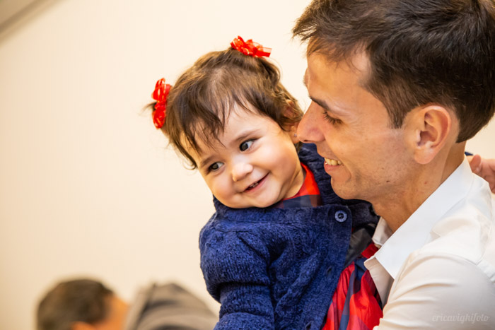 foto de festa: bebê sorrindo no colo do papai